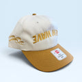 Beige and brown cap with gold text on a light blue background