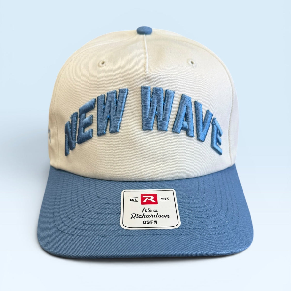 Beige and blue cap with 'NEW WAVE' text on a light blue background