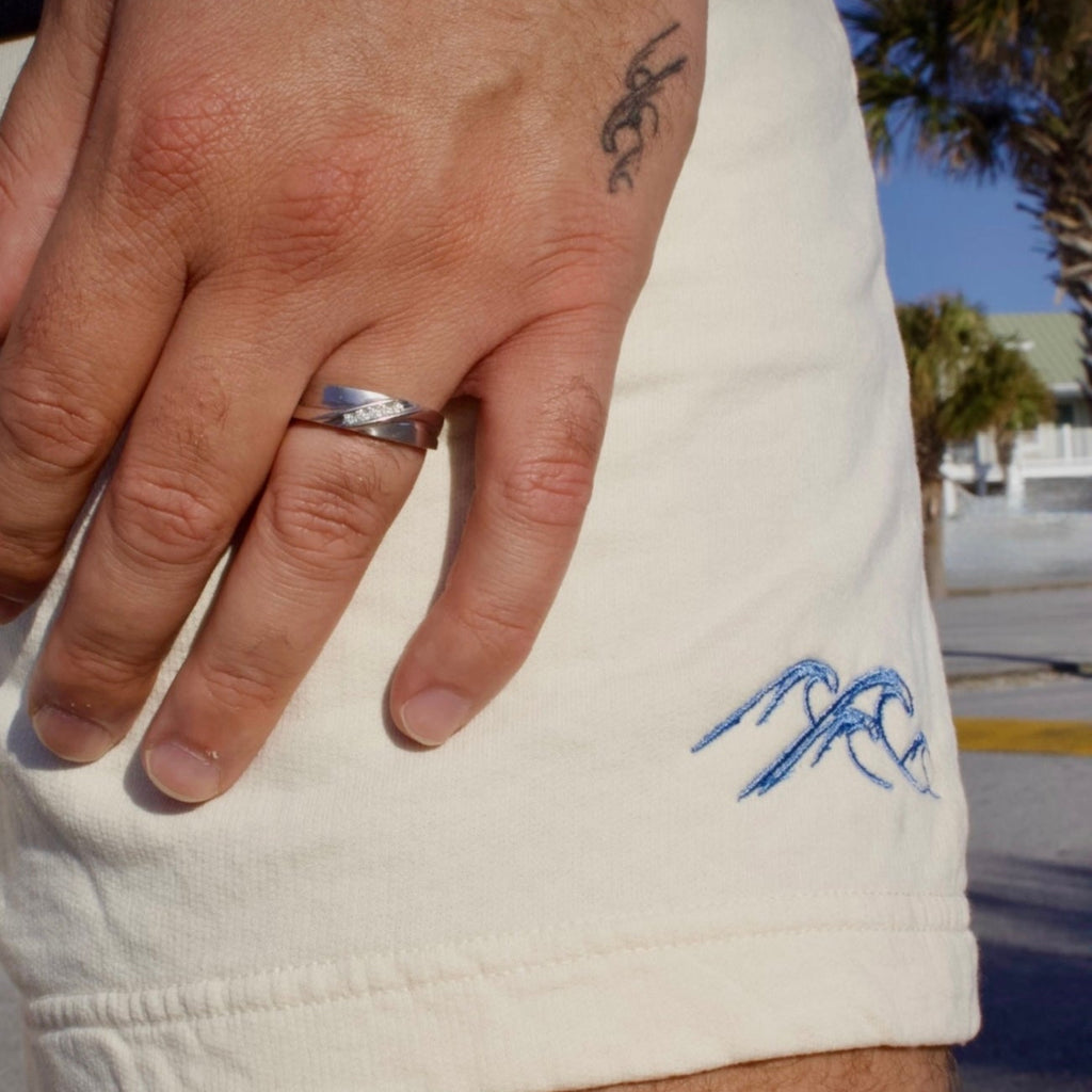 Hand with ring and tattoo on wrist, arm with Hebrew text tattoo, blurred background