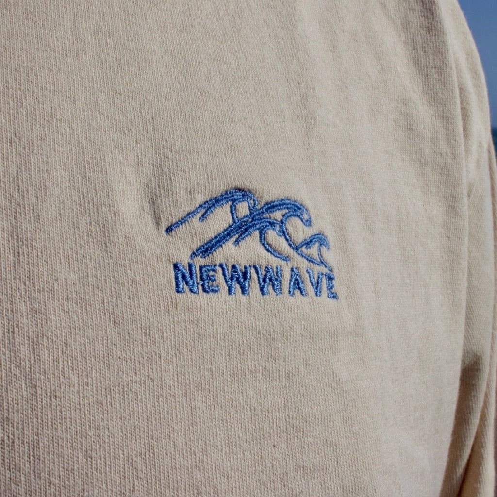 Beige sweatshirt with blue 'NEWWAVE' logo against a beach background